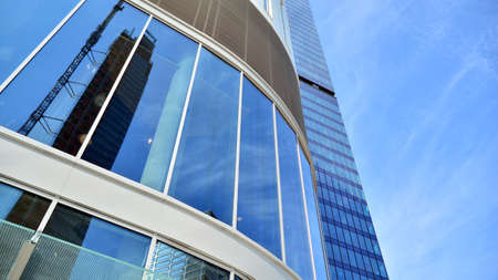 Bottom view of glass silhouette of skyscraper. Business building. Skyscraper with glass facade....
