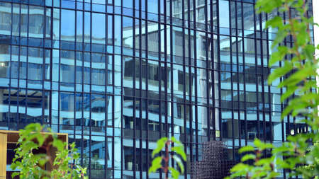 Office building, blue glass wall reflection detail. Modern office building and clear sky background.の写真素材