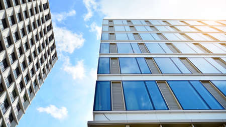 Office building, blue glass wall reflection detail. Modern office building and clear sky background.