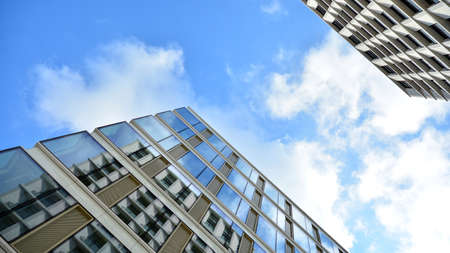 Office building, blue glass wall reflection detail. Modern office building and clear sky background.