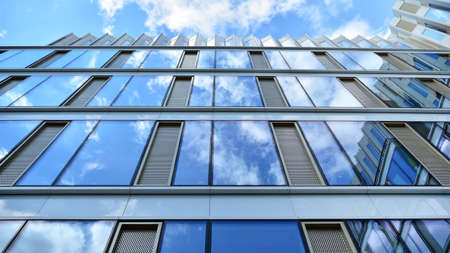 Office building, blue glass wall reflection detail. Modern office building and clear sky background.