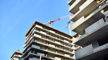 Crane and building under construction against blue sky