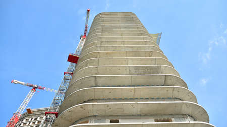 Crane and building under construction against blue sky