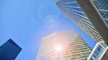 Office building, details of blue glass wall and sun reflections.