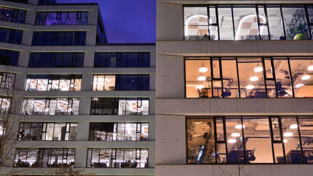 Pattern of office buildings windows illuminated at night. Lighting with Glass architecture facade...