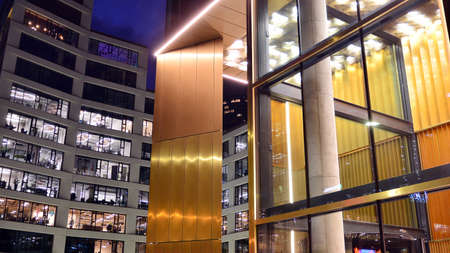 Pattern of office buildings windows illuminated at night. Lighting with Glass architecture facade...