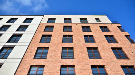 View of architectural exterior detail of residential apartment building with brick facade. Modern brick apartment building with red facade.の写真素材