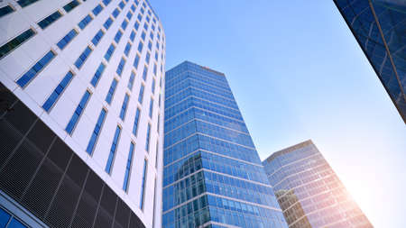 Downtown corporate business district architecture. Glass reflective office buildings against blue...