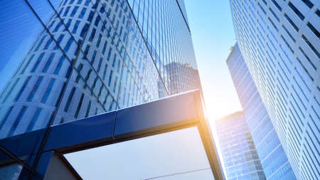 Downtown corporate business district architecture. Glass reflective office buildings against blue...