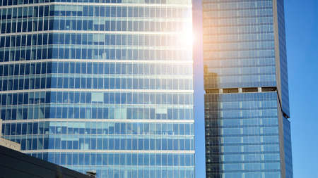 Downtown corporate business district architecture. Glass reflective office buildings against blue sky and sun light. Economy, finances, business activity concept.の写真素材