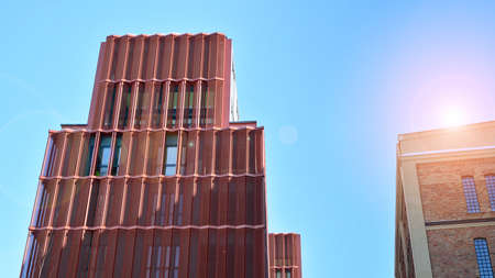 Revitalized red brick building and modern office building. Rising sun on the horizon.