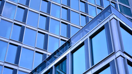 Abstract closeup of the glass-clad facade of a modern building covered in reflective plate glass....