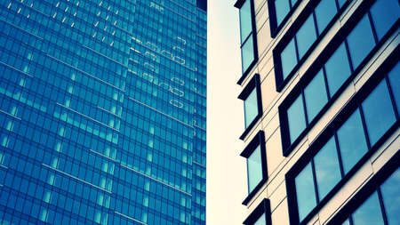 Modern building in the city with sunlight. Abstract texture and blue glass facade in modern office building., Retro stylized colorful tonal filter effect.の写真素材