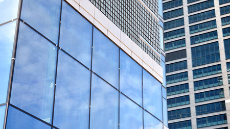 Glass clad facade of a modern building covered in reflective plate glass.