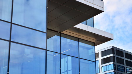 Glass clad facade of a modern building covered in reflective plate glass.