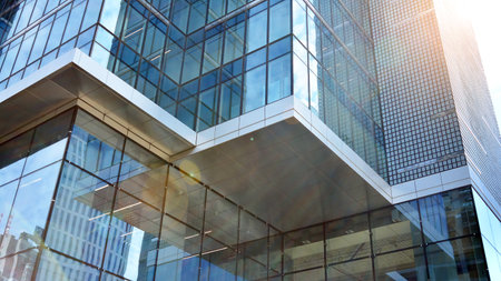 Glass clad facade of a modern building covered in reflective plate glass.