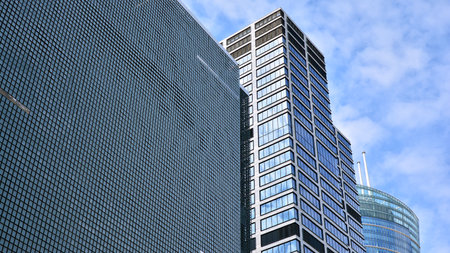 Glass clad facade of a modern building covered in reflective plate glass.