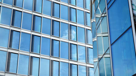 Glass clad facade of a modern building covered in reflective plate glass.