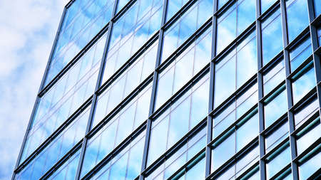 Abstract closeup of the glass-clad facade of a modern building covered in reflective plate glass....