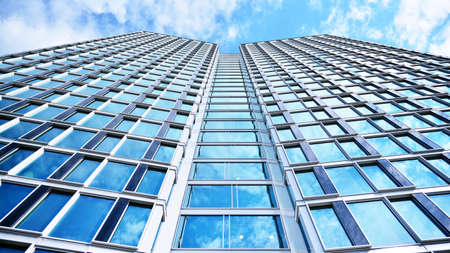 Bottom view of modern skyscrapers in business district against blue sky. Looking up at business...