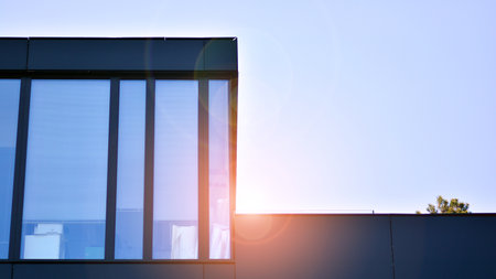 Blue sky reflection in glass facade of building. View of office building windows close up with...