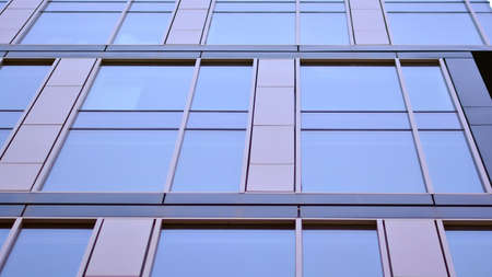 The glazed facade of an office building with reflected sky. Modern architecture buildings exterior...