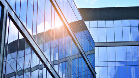Modern office building detail, glass surface on a clear sky background. Transparent glass wall of office building.の写真素材