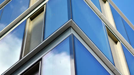 Modern office building detail, glass surface on a clear sky background. Transparent glass wall of...