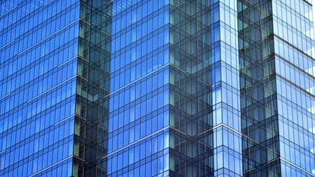 Modern office building detail, glass surface on a clear sky background. Transparent glass wall of...