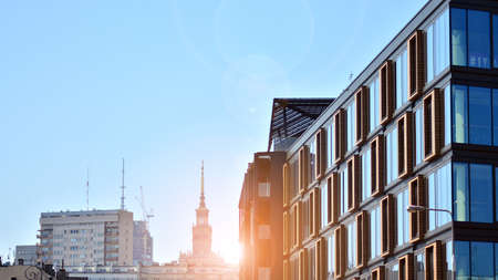 A residential building and an adjacent office building. Modern urban development. Buildings against blue sky and sun light.の写真素材
