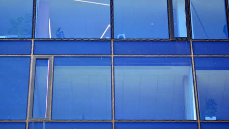 Mirrored windows of the facade of an office building. Abstract texture of blue glass modern office building. Business background.の写真素材