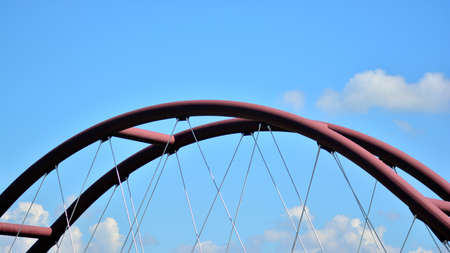 Parts of a modern metal bridge close-up against a blue sky.