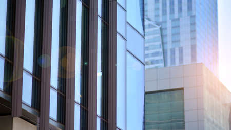 Modern architecture with sun ray. Glass and steel facade on a bright sunny day with sunbeams on the blue sky. Economy, finances, business activity concept.の写真素材