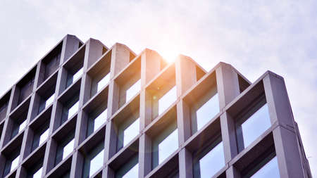 Abstract image of looking up at modern glass and concrete building. Architectural exterior detail of office building. Industrial art and detail. Sunrise.の写真素材