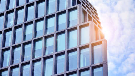 Abstract image of looking up at modern glass and concrete building. Architectural exterior detail of office building. Industrial art and detail. Sunrise.の写真素材