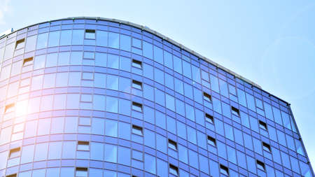 Glass and steel. Mirrored facade of modern office building with sunbeams glare reflection
