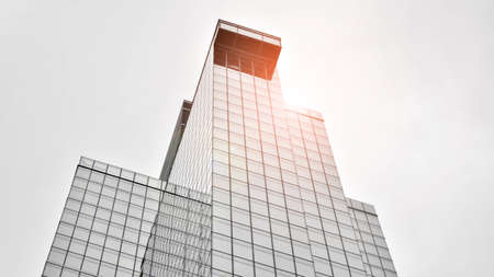 Modern architectural details. Modern glass facade with a geometric pattern. Contemporary corporate business architecture. Red sun on horizon. Black and white toned image.の写真素材