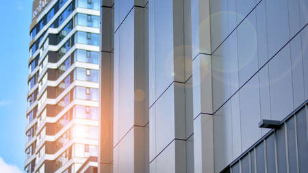 Facade texture of a glass mirrored office building. Fragment of the facade. Bottom view of modern...