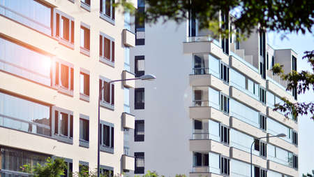 Ecological housing architecture. A modern residential building in the vicinity of trees. Ecology and green living in city, urban environment concept. Modern apartment building and green trees.の写真素材