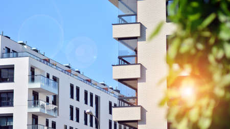 Ecological housing architecture. A modern residential building in the vicinity of trees. Ecology and green living in city, urban environment concept. Modern apartment building and green trees.の写真素材