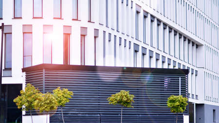 Modern glass facade with a geometric pattern. Contemporary corporate business architecture. Red sun...