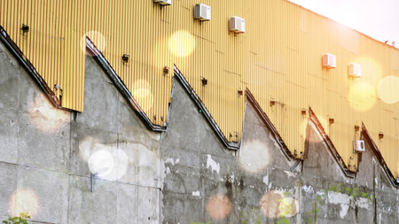 View of abandoned industrial complex. Former factory. Damaged industrial halls. Red sun on horizon, bokeh solar flareの写真素材