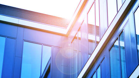 Modern office building with glass facade on a clear sky background. Transparent glass wall of office...