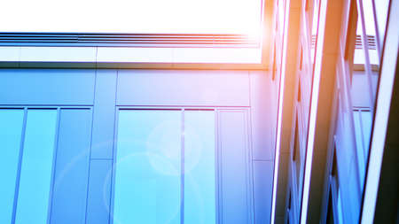 Modern office building with glass facade on a clear sky background. Transparent glass wall of office...