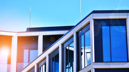 Modern office building with glass facade on a clear sky background. Transparent glass wall of office...