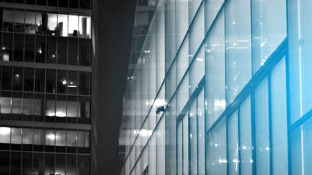 Skyscraper lobby in business district. Big glass windows in commercial skyscraper at night. Black and white.の写真素材