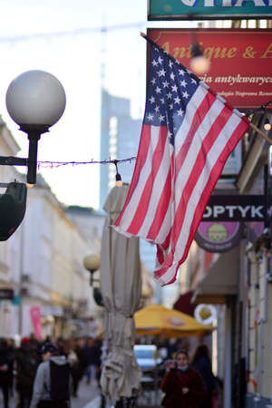 Warsaw, Poland. 24 February 2022. Chmielna street along sidewalk with hanging American flag....
