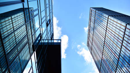 Modern office building with glass facade on a clear sky background. Abstract close up of the glass-clad facade of a modern building covered in reflective plate glass.の写真素材