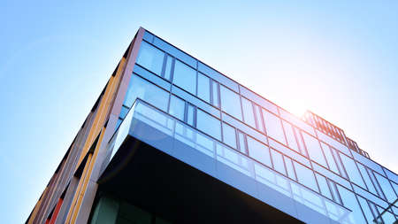 Modern office building with glass facade on a clear sky background. Abstract close up of the glass-clad facade of a modern building covered in reflective plate glass.の写真素材