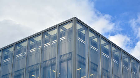 Modern office building with glass facade on a clear sky background. Abstract close up of the glass-clad facade of a modern building covered in reflective plate glass.の写真素材